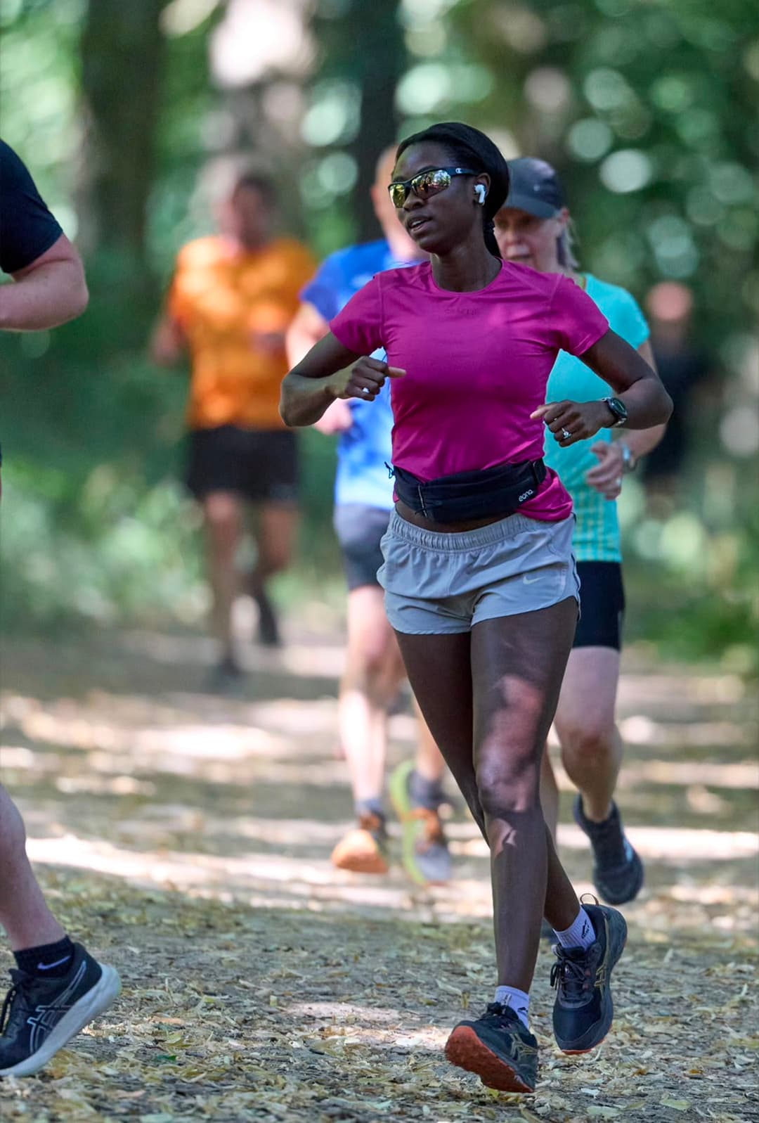 A mixed group of runners of different paces on a woodland trail